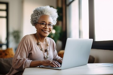 Happy senior woman using the laptop at home