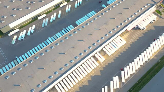 Aerial view of goods warehouse. Logistics center in industrial city zone from above. Aerial view of trucks loading at logistic center stock