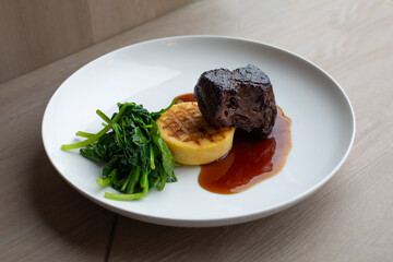 Sous Vide Braised Short Rib with Grilled Polenta on a White Plate