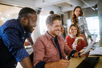 Diverse businessmen going over paperwork in a modern office