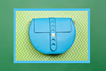 Trendy turquoise leather round-shaped woman's handbag with strap clasp isolated on a creative...