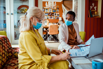 Elderly woman consulting her insurance agent at home