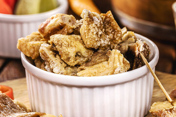 crispy fried pork rinds or bacon, served with cachaça or pinga, typical food from Minas Gerais