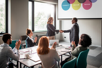 Group of diverse business people applauding a fellow colleague on a successful presentation in the conference room
