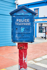 Vintage Police Telephone stand on red pole with blue box in front of shop