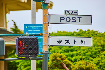 Japanese and English street sign for Post street with do not walk symbol