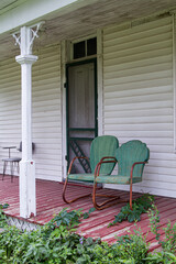 old farmhouse porch with two green chairs