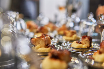 Octopus tapas ready to be served in glass covers for smoking. Creativity and science on cooking workshop