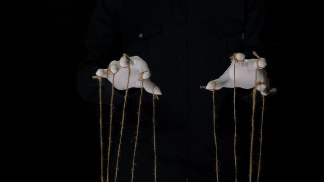 Manipulator hands in white gloves with ropes on fingers