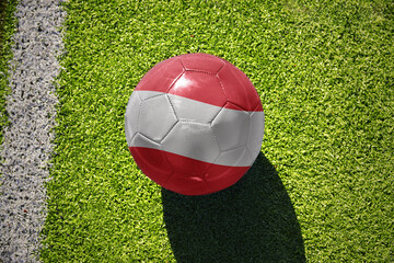 football ball with the flag of austria on the green field near the white line