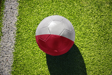 football ball with the flag of poland on the green field near the white line