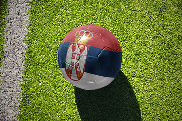 football ball with the flag of serbia on the green field near the white line