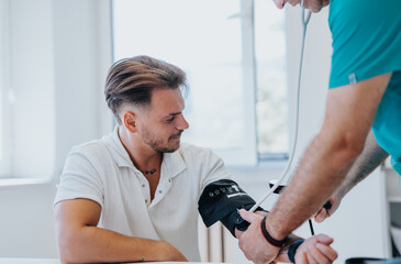 Experienced Doctor Monitoring Heart Rate of Young Male Patient in Indoor Office