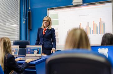Well-dressed professor giving a lecture to her students about graphs and charts
