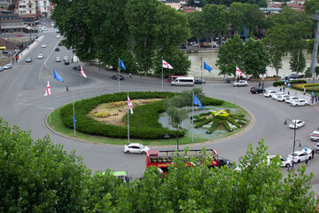 View from above. Urban view of round Europe square in Georgian city of Tbilisi. Cityscape. Trees...
