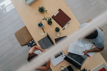 Business team collaborates in a modern indoor office. Focus on efficiency, growth, data analysis, and marketing strategy. Diverse and driven coworkers strive for success in a dynamic workspace.