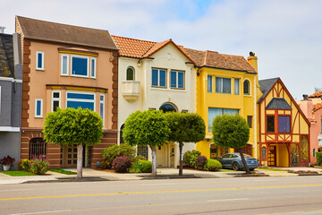 Row of 3 pastel San Francisco, USA homes in brown and yellow by street