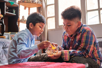 two latin kids eating dulce de leche in one room - obrazy, fototapety, plakaty