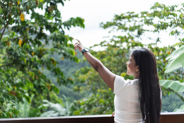 Fototapeta premium A woman points at the horizon from a balcony