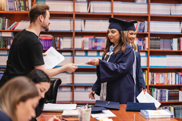 Young group of university graduates filling out their forums with the guidance of their mentor at...