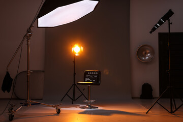 Casting call. Chair, clapperboard and different equipment in modern studio - obrazy, fototapety, plakaty