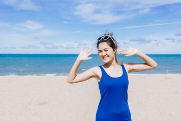 Happy and cheerful asian woman in blue dress on the sunny beach of Thailand.