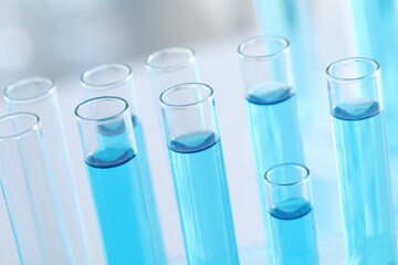 Test tubes with light blue liquid in laboratory, closeup