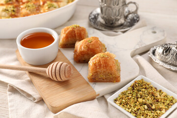 Delicious sweet baklava with pistachios and honey on table