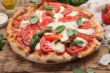 Delicious Caprese pizza with tomatoes, mozzarella and basil on wooden table, closeup