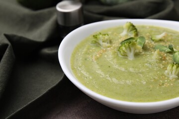 Delicious broccoli cream soup on table, closeup