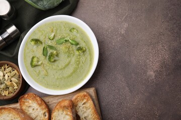 Delicious broccoli cream soup served on grey table, flat lay. Space for text