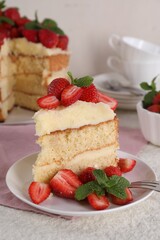 Piece of tasty cake with fresh strawberries and mint on white table