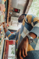 Diverse colleagues brainstorm and collaborate in a modern office. They write on sticky notes placed on a glass wall, sharing innovative ideas and strategies, fostering a dynamic work environment.