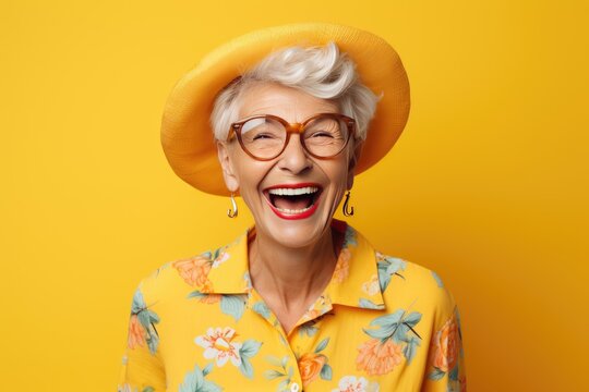 portrait of a cheerful smiling elderly grandmother in glasses on a yellow background