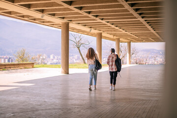 Back view shot of two school girls walking at the school yard