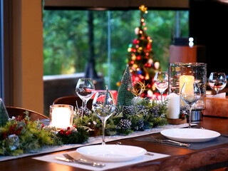 close up dining table setting for Christmas eve family party with wine glasses