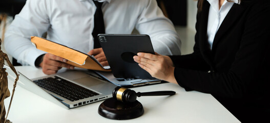 Judge gavel with Justice lawyers having team meeting at law firm in background. Concepts of law.