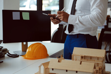 Obraz premium Construction and structure concept of Engineer or architect meeting for project working with partner and engineering tools on model building and blueprint in working site, contract for both companies.