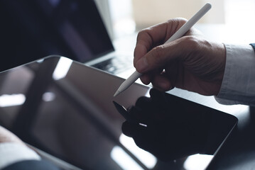 Close up, businessman using stylus pen signing e-document on digital tablet at office, E-signing, electronic signature concept. Business man online working on computer devices on office desk