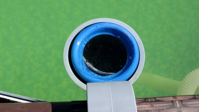 4k video, filter purifies water in an outdoor frame country pool from insects and debris, close-up