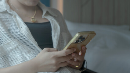 Happy woman on sofa and using smartphone to enjoy online shopping and social media.