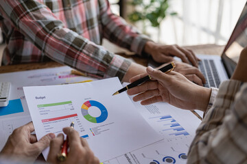 Young businessman brainstorms to analyze and plan business strategies with laptop and financial report graph documents. Close-up image