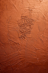 Artistic plaster trowel pattern on an orange wall with intense texture