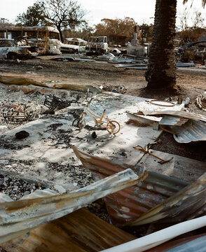 Detail of bushfire ravaged town with destroyed vehicles and buldings