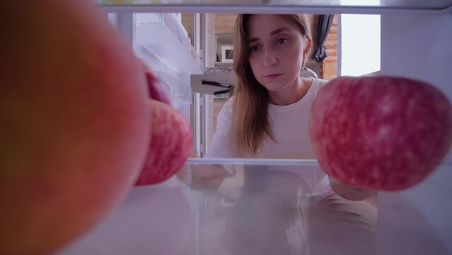 Point of view: woman is taking fruit out of the fridge, refrigerator, inside pov shot - healthy food, diet concept