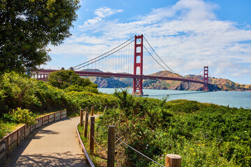 Path with railing leading to Golden Gate Bridge in San Francisco Bay on gorgeous summer day