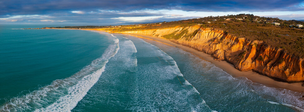 Aerial panorama view of coastal sea cliffs in early morning sunshine