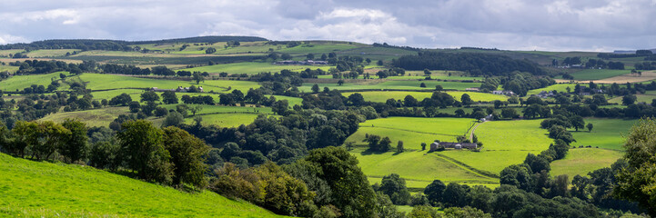 Fototapeta na wymiar a panoramic view looking across pastures and farms on hill and dale in Cumbria, near Walton, UK