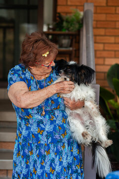Senior woman interacting with her pet dog outside home