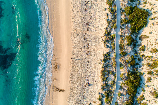Looking down on ocean, beach, and coastal pathway.
